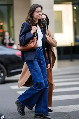 A person wearing a blazer, jeans, and Dr. Martens boots. 