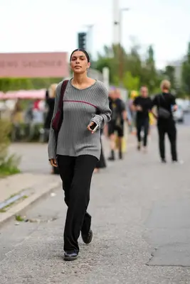 A person wears a sweater with Dr. Martens. 