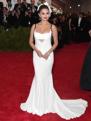 Selena Gomez wears a white Vera Wang gown and hair accessory to the 2015 Met Gala