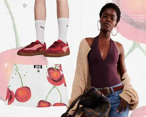 Red Puma Palermo sneakers with crew socks on model, woman wearing burgundy bodysuit, sweater, and jeans, and cherry-patterned mini skirt
