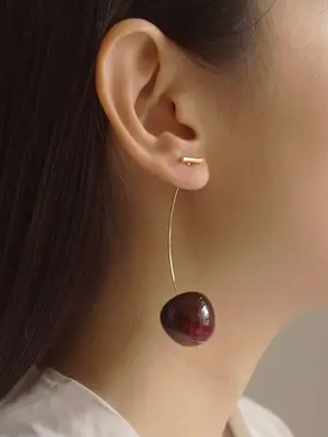 Close-up of woman wearing cherry stem earring