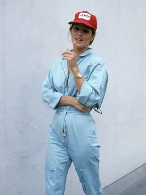 Priscilla Presley wears a light wash denim jumpsuit, red 