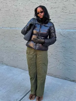 Imani Randolph wearing sunglasses, black puffer jacket, green cargo pants, and fur Tabi shoes