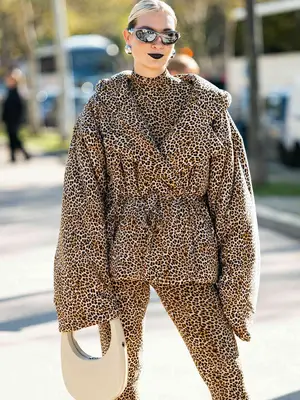 Ellie Delphine wearing black puffer jacket with white headband and sunglasses.