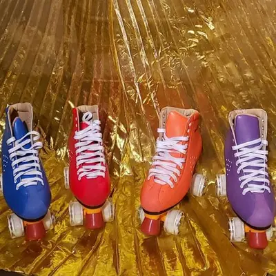 Church of 8 Wheels Blue Royale skate next to red, orange, and purple roller skates