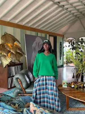 Toni Bravo wearing a tartan skirt with a green sweater and green hat