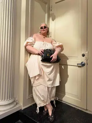 Abby Bible wearing a cream top and long bloomers with ballet flats and bohemian handbag