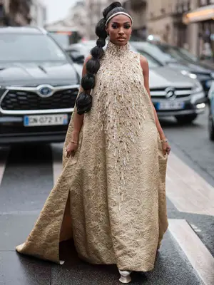 Woman wearing a high-neck sleeveless voluminous maxi dress and headband