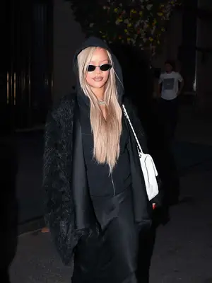 Rihanna walking outside wearing black hoodie zip up, straight blonde hair, micro sunglasses