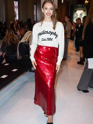 Martina Strazzer wears a Philosophy logo sweater, red sequin maxi skirt, and strappy heels