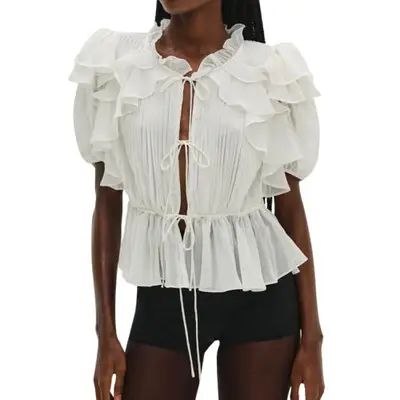 Model wearing a white ruffled blouse with short sleeves