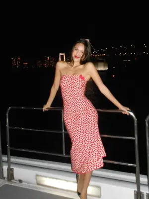 Olivia Rodrigo wears a red heart polka dot patterned strapless midi dress