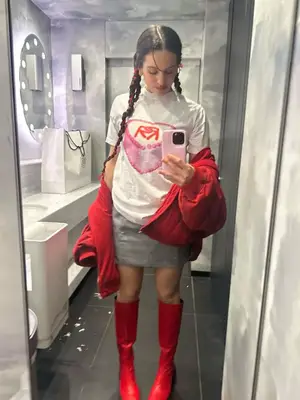 Rosalia wearing a t-shirt, gray skirt, red jacket, and red rain boots