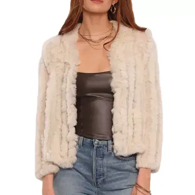 person wearing a textured jacket in a cream color