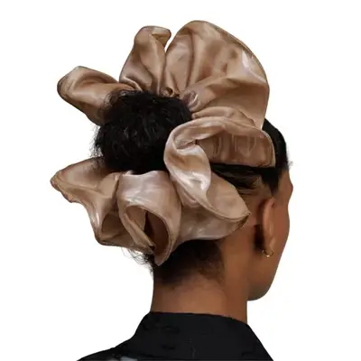 person wearing a beige hair scrunchie