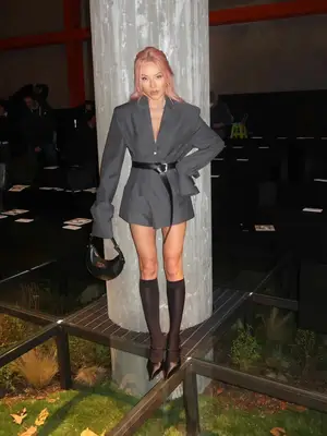 Tina Leung wearing grey blazer dress, black belt, knee high socks, black purse, heels