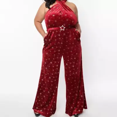 Model wearing a red velvet jumpsuit with silver stars on it 