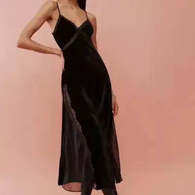 Model wearing a long black velvet and lace dress 