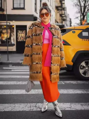 Audree Kate Lopez wearing an animal print fur coat, pink button-down shirt worn open, pink tank top, orange maxi skirt, and silver boots - Fall/Winter Coat Trends MYM Beauty