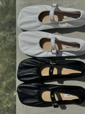 black and white Sandy Liang ballet flats by a pool
