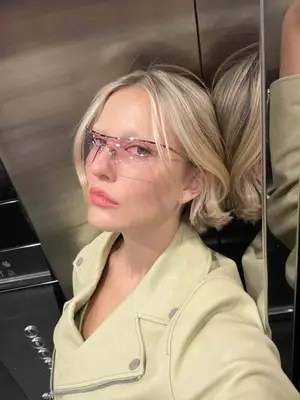 Woman wears light pink sporty sunglasses and butter yellow leather jacket