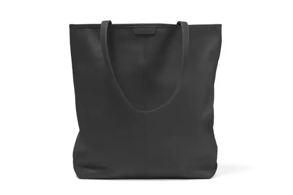 A person placing their hand in the side pocket of the Monos Metro Carry All Duffel