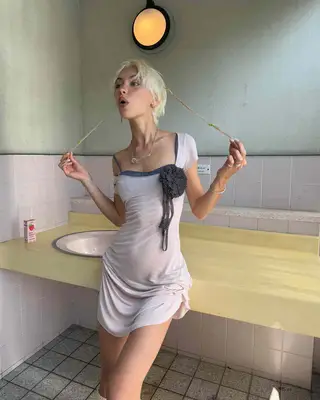 Iris Law wearing a pink dress with a flower