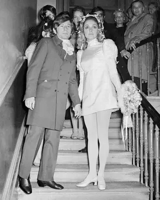 Sharon Tate with Roman Polanski on their wedding day wearing a white satin mini dress