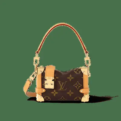 louis vuitton monogrammed mini trunk handbag with handle and gold hardware against plain background