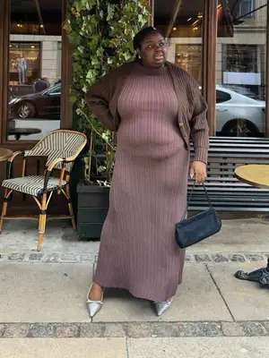 Abisola Omole wearing a monochromatic brown outfit of dress and blazer with black bag