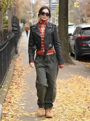 Emily Ratajkowski wears a denim moto jacket, striped top, cargo pants, and Timberlands