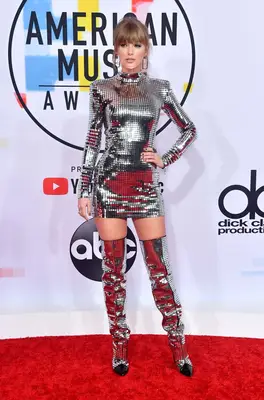 Taylor Swift wearing a disco-inspired mini dress and matching thigh-high boots at the 2018 American Music Awards