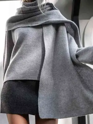 Close-up of hand with black leather glove, gold ring, and gray coat sleeve