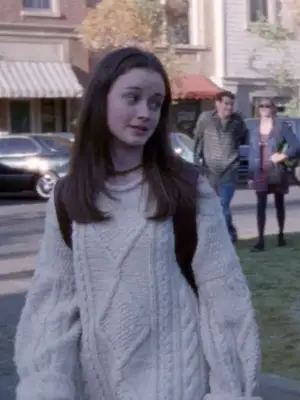 Rory Gilmore wears an oversized white cable knit sweater and backpack