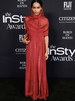 Zoe Kravitz wears a red hooded dress and matching clutch to the 2021 InStyle Awards