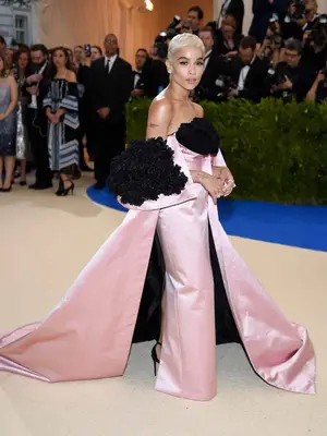 Zoe Kravitz wears a pale pink satin Oscar de la Renta dress with black rose petals to the 2017 Met Gala
