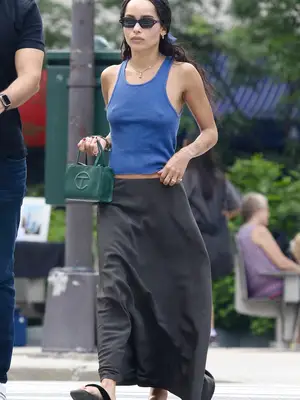 Zoe Kravitz wears a blue tank top, gray maxi slip skirt, and green Telfar bag