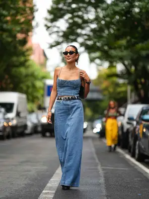 Woman wearing denim corset top and maxi skirt with angular sunglasses