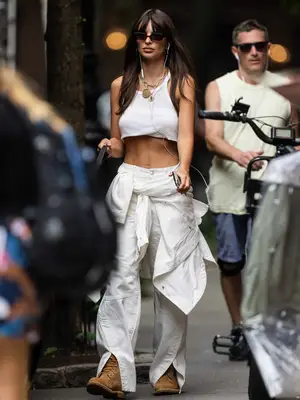 Emily Ratajkowski wears a white cropped tank, wide leg jeans, and Timberland boots