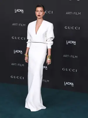 Hailey Bieber wears a white Saint Laurent gown with plunging neckline to the LACMA Art + Film Gala
