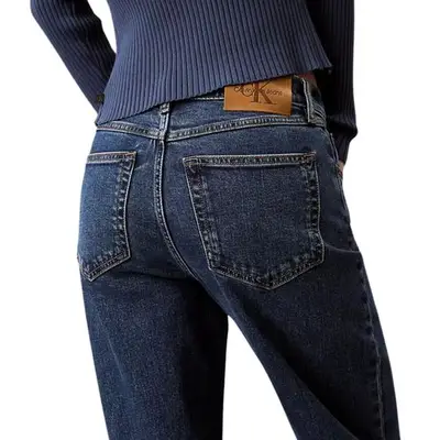 person wearing dark wash denim