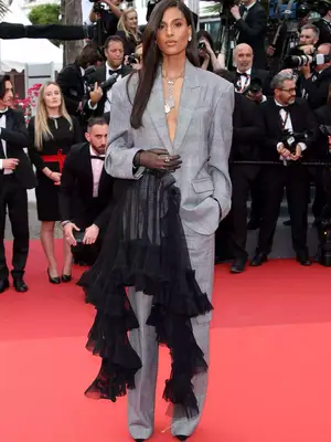 Cindy Bruna wears a gray Act No. 1 suit with black ruffle detail to the 2023 Cannes Film Festival