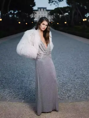 Kaia Gerber wears a silver sparkly Celine gown with plunge neckline and fur jacket at Cannes 2023