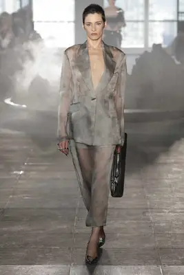 Model wears sheer hazy gray skirt suit with black handbag and silver heels at the Grace Ling Spring 2025 show