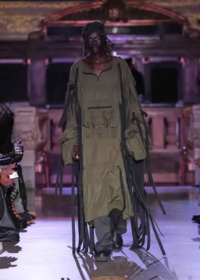 Model wearing utilitarian jacket dress and pants on the Who Decides War Spring 2025 runway