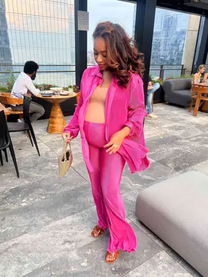 MYM Beauty editor Aimee Simeon wears a pink ribbed button-down and pants set and a nude bodysuit