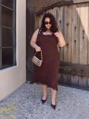 Nadia Aboulhosn wears a brown midi dress with fringe, patterned bag, rectangle sunglasses, and pointed-toe slingbacks