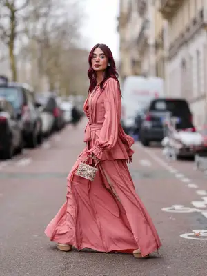 Woman wearing pink dress and pearl-embellished handbag