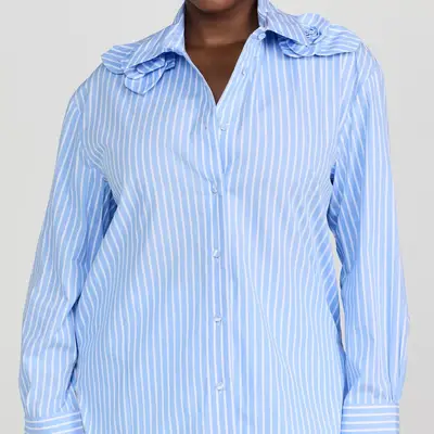 Aknvas blue and white striped button-down blouse with floral shoulder detailing on model