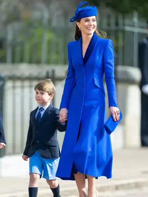 Kate Middleton wearing a bright blue coat dress with a blue hat 
